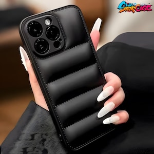 Op de afbeelding: Zwarte gewatteerde telefoonhoes met een gestikte rand. De hoes heeft een glanzende afwerking en een verhoogd ontwerp. De telefoonhoes heeft een camera-uitsparing en de tekst "Chic SnapCase" rechtsboven.