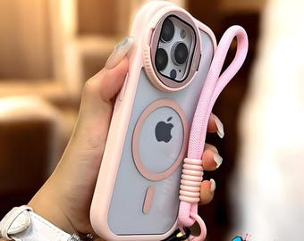 May include: A pink phone case with a matching pink lanyard. The case has a clear back with a pink circle and a cutout for the Apple logo. The case has a pink bumper and a pink camera ring. The lanyard is attached to the bottom of the case.