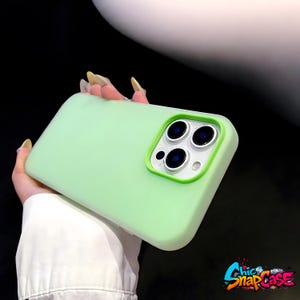 May include: A light green phone case with a green camera border. The case has a smooth finish and is designed to fit a smartphone. The Chic Snap Case logo is visible in the bottom right corner.