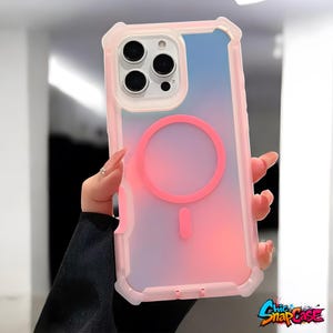 May include: A pink and clear phone case with a gradient design, featuring a pink magnetic circle and a matching charging port indicator. The case has a protective bumper and a clear back, with the text "Chic SnapCase" in the bottom right corner.