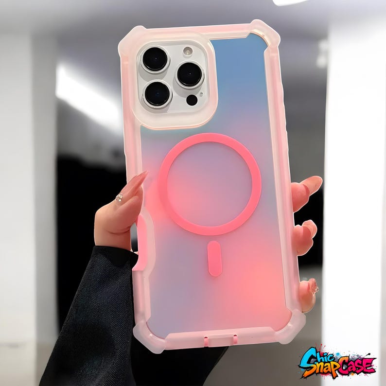 May include: A pink and clear phone case with a gradient design, featuring a pink magnetic circle and a matching charging port indicator. The case has a protective bumper and a clear back, with the text "Chic SnapCase" in the bottom right corner.