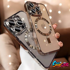 May include: Two clear phone cases with metallic gold-colored trim and camera lens protectors. One case is a light gray color, and the other is a light tan color. The cases have a circular design on the back. The text "Chic SnapCase" is in the bottom right corner.