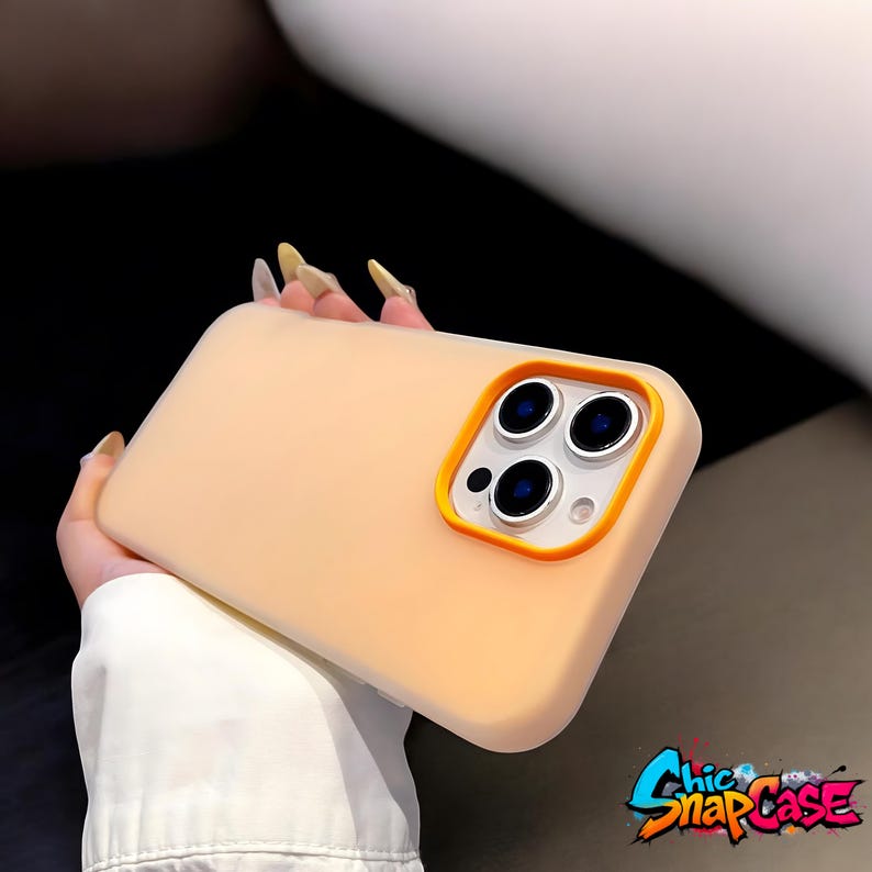 May include: A peach-colored phone case with an orange camera border. The case has a matte finish and is designed for a smartphone. The brand name "Chic Snap Case" is visible in the bottom right corner.