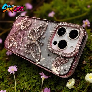 May include: A pink and silver phone case with a butterfly design. The case has a glittery background and a raised butterfly with rhinestone accents. The camera lens is surrounded by rhinestones. The text "Chic SnapCase" is visible.