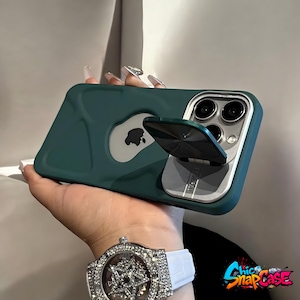 May include: A teal phone case with a silver camera frame and a built-in stand. The case has a silver Apple logo and the stand is open. The watch on the wrist has a white band and a silver face.