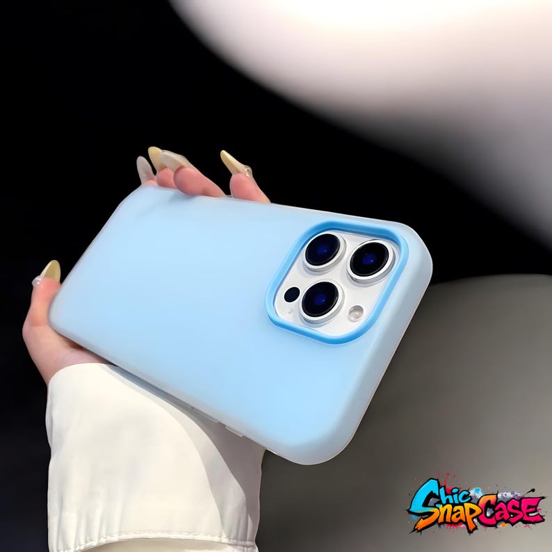 May include: A light blue phone case with a blue camera border. The case has a smooth finish and is designed to fit a smartphone. The Chic Snap Case logo is in the bottom right corner.