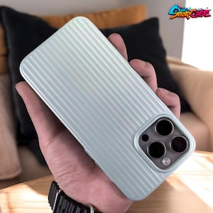 Könnte beinhalten: Hellgrüne Handyhülle mit gerilltem Design. Die Hülle hat einen quadratischen Kameraausschnitt mit drei Objektiven. Der Text "Chic SnapCase" befindet sich in der oberen rechten Ecke.