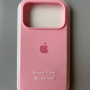 Könnte beinhalten: Eine hellrosa Silikon-Handyhülle für ein iPhone 17 Pro in der originalen, durchsichtigen Kunststoff-Verkaufsverpackung. Die Hülle zeigt ein zentriertes Apple-Logo und den in Weiß aufgedruckten Text "iPhone 17 Pro Silicone Case" auf der Vorderseite.