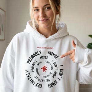 May include: White hoodie featuring the word "OVERTHINKING" above a circular design with the words "PROBABLY", "MAYBE", "DEFINITELY", and "I DON'T KNOW". A red floral design is in the centre. The hoodie has a drawstring hood.