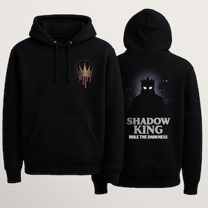 Pode incluir: Moletom preto com capuz com um design de coroa dourada na frente e um gráfico maior nas costas. O gráfico nas costas apresenta uma figura em silhueta com uma coroa e o texto "SHADOW KING RULE THE DARKNESS".