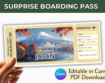 May include: A beige boarding pass featuring a scenic image of Mount Fuji surrounded by autumn foliage. The text reads "SURPRISE BOARDING PASS," "Adventure Awaits," "You're going to JAPAN," "Emilie Thomson," "10.11.2026," "20.11.2026," "Mount Fuji, Japan," and "Enjoy the Journey!"
