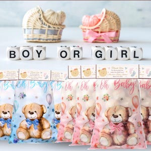 May include: Baby shower candy bag toppers featuring teddy bear designs in blue and pink. The toppers are folded and available in 8.5 x 11 inch and A4 sheet sizes. The text "Boy or Girl" is displayed with baby-themed decorations.