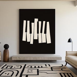 May include: A contemporary living room with a large black and white abstract artwork. A patterned rug with black geometric shapes is on the floor. The room includes a neutral-toned sofa, a black side table, and a wooden sculpture.