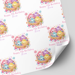 Peut inclure: Papier cadeau avec un motif répétitif de paniers vapeur en bambou remplis de raviolis de dessin animé colorés et souriants avec des bonbons. Le texte "Happy 7th Birthday Ava" est imprimé en rose à côté de chaque illustration.