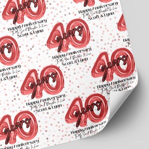 May include: White wrapping paper featuring a repeating pattern of red balloon-style numbers 40, the word years in black script, and small red stars. The text reads Happy Anniversary To My Son & Daughter In Law SCOTT & LYNN.