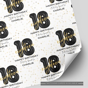 May include: White wrapping paper featuring a repeating pattern of black balloon-style numbers 18, the gold cursive word eighteen, and the text HAPPY BIRTHDAY To A Very Special Son CHARLIE, all set against a background of small gold stars.
