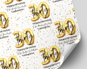 May include: White wrapping paper featuring a repeating pattern of gold foil balloon-style numbers 30, the word thirty in black script, and small gold stars. Text reads: Happy Birthday To Our Beautiful Granddaughter Samantha.