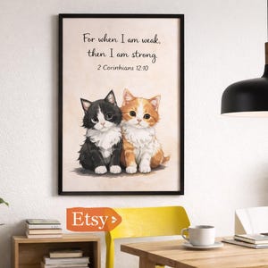 May include: Framed art print featuring two adorable watercolor kittens, one black and white, the other orange and white. The print includes the text "For when I am weak, then I am strong. 2 Corinthians 12:10."