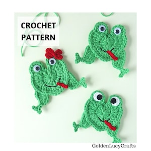 May include: Three green crochet frog appliques with googly eyes and red tongues. One frog has a red bow. The image includes the text "CROCHET PATTERN" and the GoldenLucyCrafts logo.