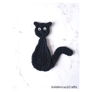 May include: Black crocheted cat with white googly eyes.