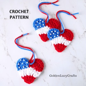 May include: Crochet heart ornaments in red, white, and blue, resembling the American flag. Each heart has a blue section with white bead accents and red and white stripes. The text "CROCHET PATTERN" is visible.