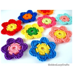 May include: A collection of colorful crocheted flowers in various shades of red, orange, yellow, green, blue, and pink. The flowers are all the same size and shape, and they are arranged in a random pattern.
