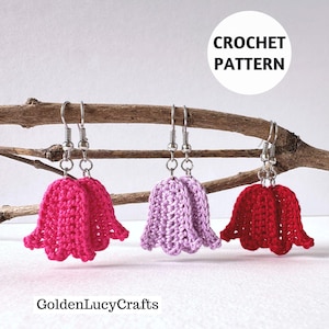 May include: Three handmade crochet flower earrings in pink, lavender, and red hang from a twig. The earrings have silver-colored hooks. The image includes the text "CROCHET PATTERN" in a white circle and the text "GoldenLucyCrafts".