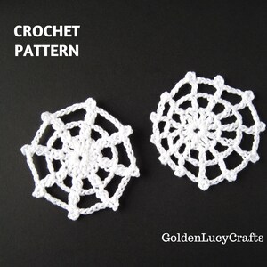 May include: Two white crocheted snowflake patterns on a black background. The text "CROCHET PATTERN" is at the top. The patterns are circular with a web-like design. The text "GoldenLucyCrafts" is at the bottom.