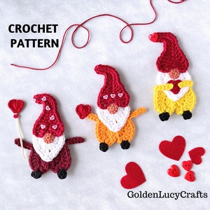 May include: Three crocheted gnomes with red, white, and yellow yarn. Each gnome is holding a red heart. The gnomes are on a white background with red felt hearts and buttons.