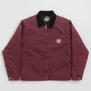 Può includere: Giacca da lavoro bordeaux con colletto in velluto a coste nero. La giacca ha una cerniera a tutta lunghezza, due tasche anteriori e una piccola tasca sul petto. Sono visibili una cerniera dorata e una piccola toppa con logo. Materiale resistente.