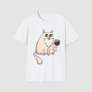 Peut inclure: T-shirt blanc avec un dessin de chat de dessin animé. Le chat a une longue barbe blanche et tient un verre de vin rouge. Le design est une représentation humoristique d'un chat appréciant le vin.