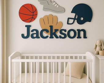 Könnte beinhalten: Ein an der Wand montiertes Set aus sportlichen Holzausschnitten mit einem Basketball, einem geflügelten Turnschuh, einem Baseballhandschuh und einem dunkelblauen Footballhelm über dem Namen Jackson in dunkelblauer, fetter Serifenschrift.
