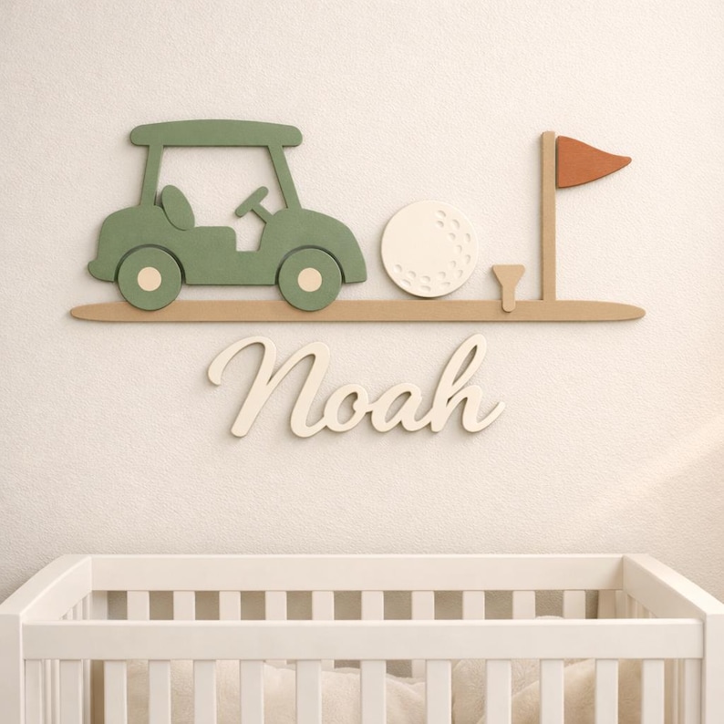 May include: A wall-mounted wooden sign featuring a sage green golf cart, a white golf ball, a small tee, and a rust-colored flag on a tan base. Below the golf elements, the name Noah is written in large, cream-colored cursive script letters.