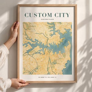 May include: A framed map print featuring a stylised city layout with yellow land masses and blue water bodies. The text CUSTOM CITY and CUSTOM PLACE appear at the top, while the coordinates 33.8688 S, 151.2093 E are printed at the bottom.