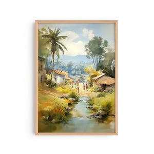 May include: Watercolor painting of a village scene with a river, palm trees, and small houses. The artwork is framed in a light wood frame. People are walking along a dirt road. The sky is blue with white clouds.