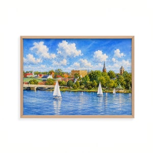 May include: A framed landscape painting depicting a blue river with three white sailboats under a bright blue sky with white clouds. The background features a town with green trees, a stone bridge, and various buildings including a church steeple.