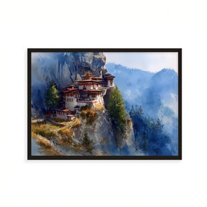 May include: A framed watercolor print of a mountain monastery. The building has red and white walls and a tiered roof. The artwork is set against a backdrop of misty blue mountains and green trees. The frame is black.
