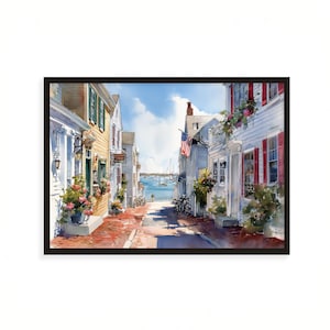 Puede incluir: Pintura a la acuarela de una escena callejera de un pueblo costero. Edificios con fachadas blancas y amarillas bordean una calle pavimentada con ladrillos que conduce al océano. Una bandera estadounidense ondea en la brisa. Hay bicicletas aparcadas en la calle.