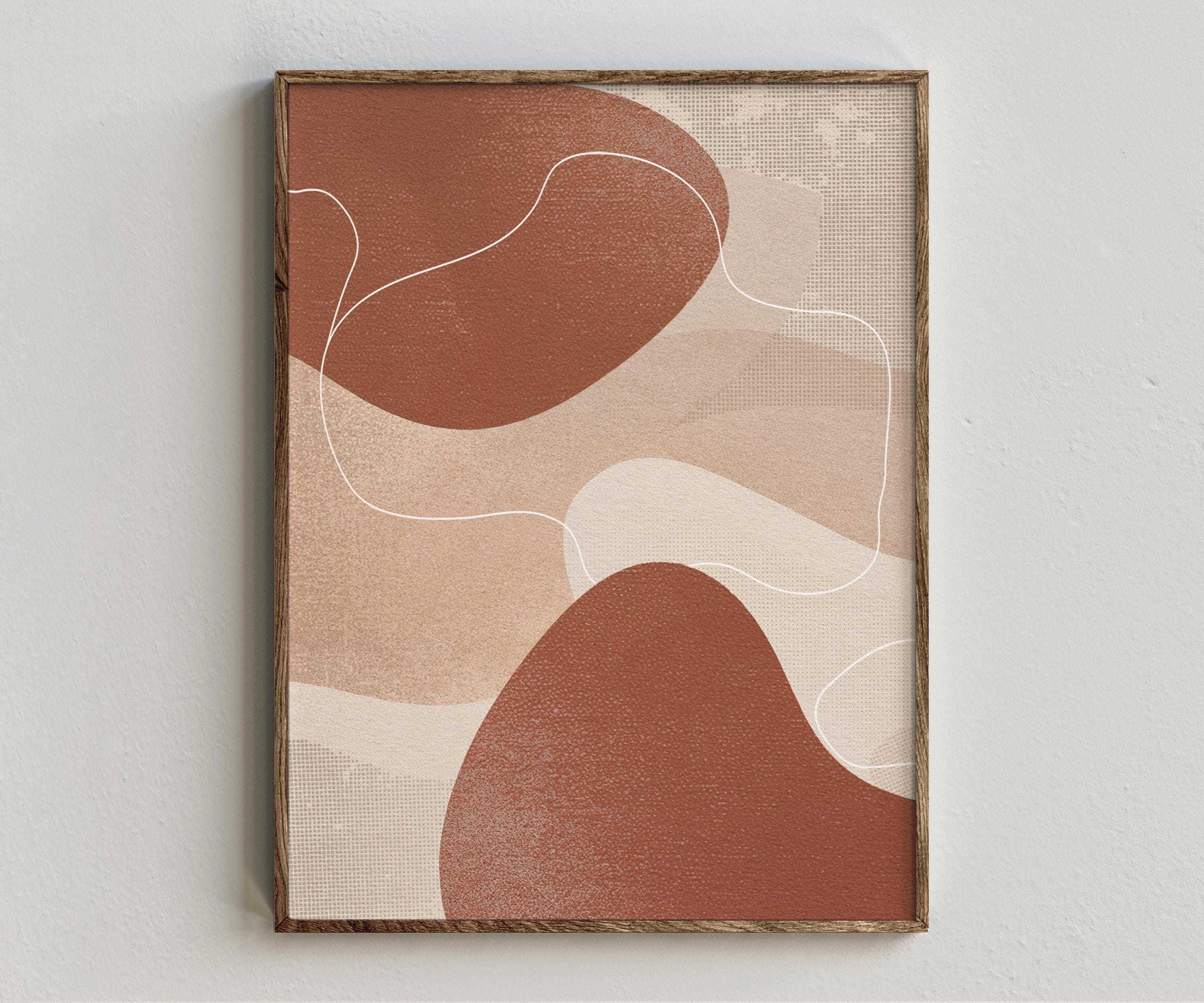 Framed artwork “Synergy - Terracotta” showing terracotta abstract composition with rust organic forms, soft beige layers, white curved linework on a white wall.