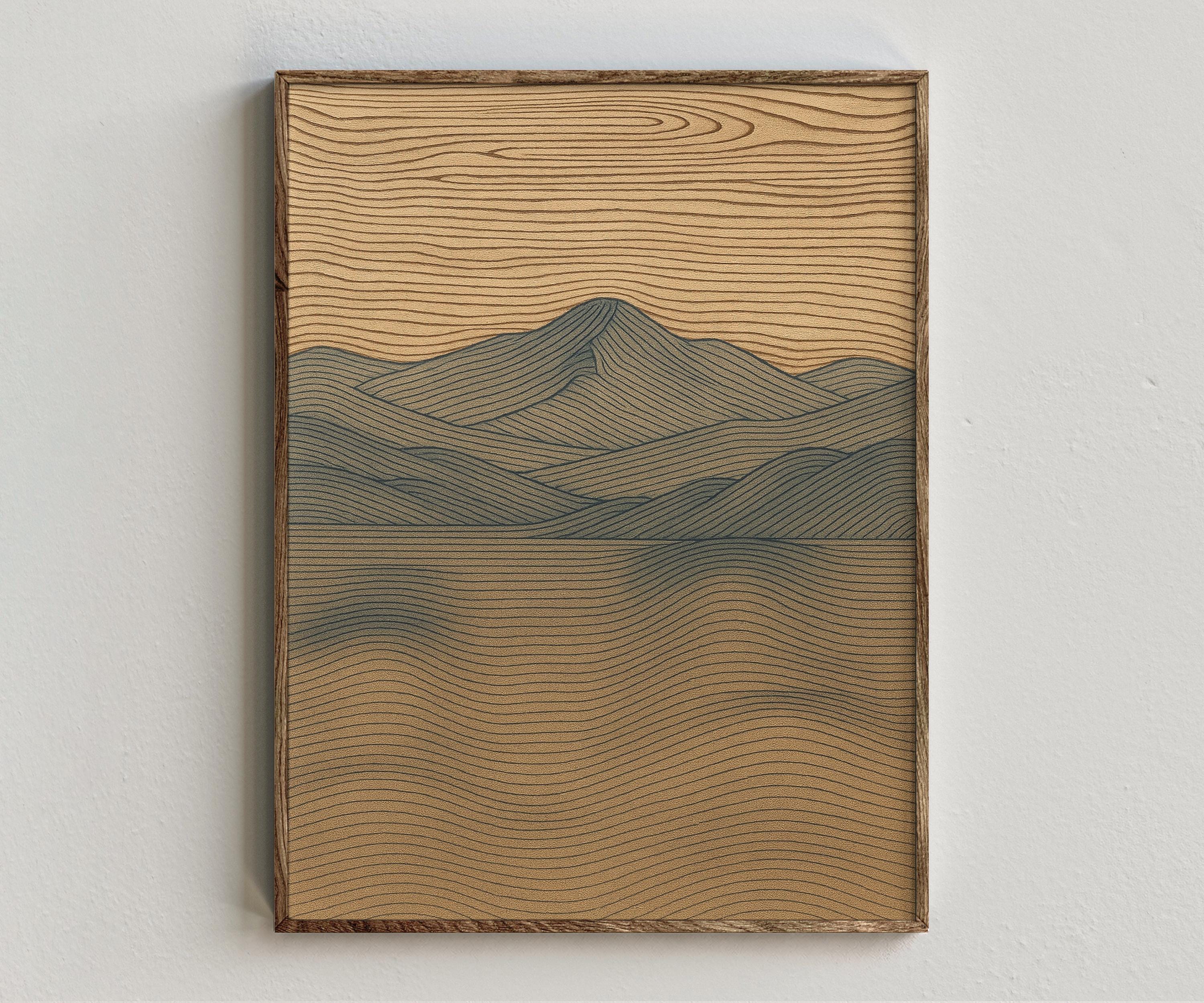 Framed artwork “Echo Wood” showing mountain lake composition with muted blue water, soft mountain forms, brown contour lines, and textured neutral horizon style on a white wall.