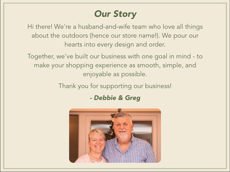 May include: A rectangular sign with a light beige background and dark green text titled Our Story. The text introduces a husband-and-wife team named Debbie and Greg, followed by a photograph of the couple smiling together in an indoor setting.