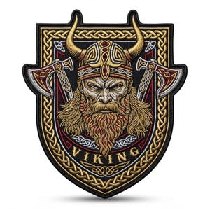 Puede incluir: Un parche bordado en forma de escudo que presenta a un guerrero vikingo central con casco de cuernos y barba larga, flanqueado por dos hachas de batalla cruzadas. El diseño incluye bordes dorados de nudos celtas y la palabra VIKING en oro.