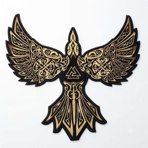 Könnte beinhalten: Ein schwarz-goldener Stickaufnäher in Form eines Raben mit ausgebreiteten Flügeln. Das Design zeigt komplizierte keltische Knotenmuster auf den Flügeln und dem Körper, mit einem zentralen Valknut-Symbol auf der Brust des Vogels.