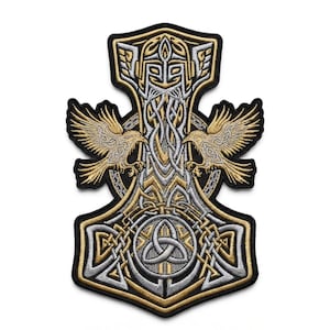 May include: An embroidered patch shaped like Mjolnir, featuring a central helmeted figure, two flanking ravens, and a triquetra knot symbol. The design uses metallic gold, silver, and black thread with intricate Celtic-inspired knotwork patterns.