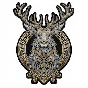 Op de afbeelding: Een geborduurde patch met een gedetailleerde hertenkop met groot gewei, gecentreerd in een cirkelvormig frame van gouden en zilveren Keltische knopen. Het ontwerp gebruikt gouden, zilveren en zwarte draad voor een textuur en gedetailleerd uiterlijk.