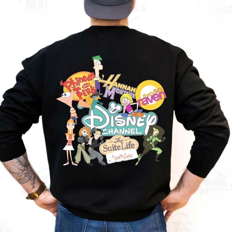 Pode incluir: Camisola preta com um gr&aacute;fico colorido do Disney Channel com personagens de Phineas and Ferb, Hannah Montana, That's So Raven, Kim Possible e The Suite Life of Zack & Cody. A camisola tem mangas compridas.