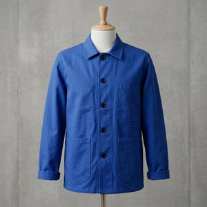 Peut inclure: Veste bleu vif de style classique, avec un col, des manches longues et quatre boutons noirs sur le devant. La veste possède deux poches de poitrine et deux poches basses. Les manches sont retroussées. La veste est présentée sur un mannequin.