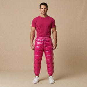 May include: A short-sleeved fuchsia t-shirt paired with matching fuchsia quilted puffer pants. The pants feature a high-shine, glossy finish, horizontal stitching, an elasticized waistband with a drawstring, and cuffed ankles. The outfit is completed with white sneakers.