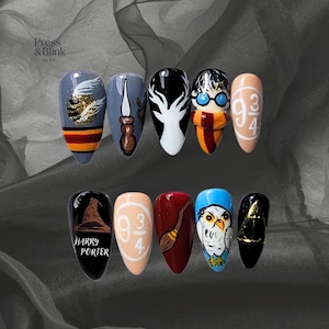 May include: A set of ten press-on nails featuring designs inspired by the Harry Potter series. Designs include the Hogwarts crest, Harry Potter, the Sorting Hat, a broom, and the 9 3/4 platform. The nails are in various colors, including black, white, and gold.