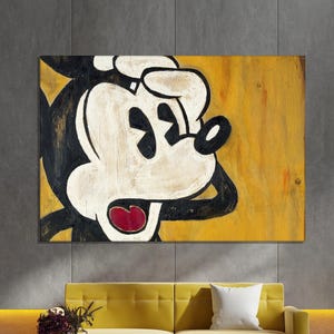 Könnte beinhalten: Große Leinwandkunst mit einem verwitterten Bild von Mickey Mouse mit überraschtem Gesichtsausdruck. Das Kunstwerk verwendet eine Palette aus Schwarz, Weiß und Rot vor einem gelben Hintergrund und erzeugt eine Vintage-Ästhetik. Die Leinwand ist über einem gelben Sofa montiert.